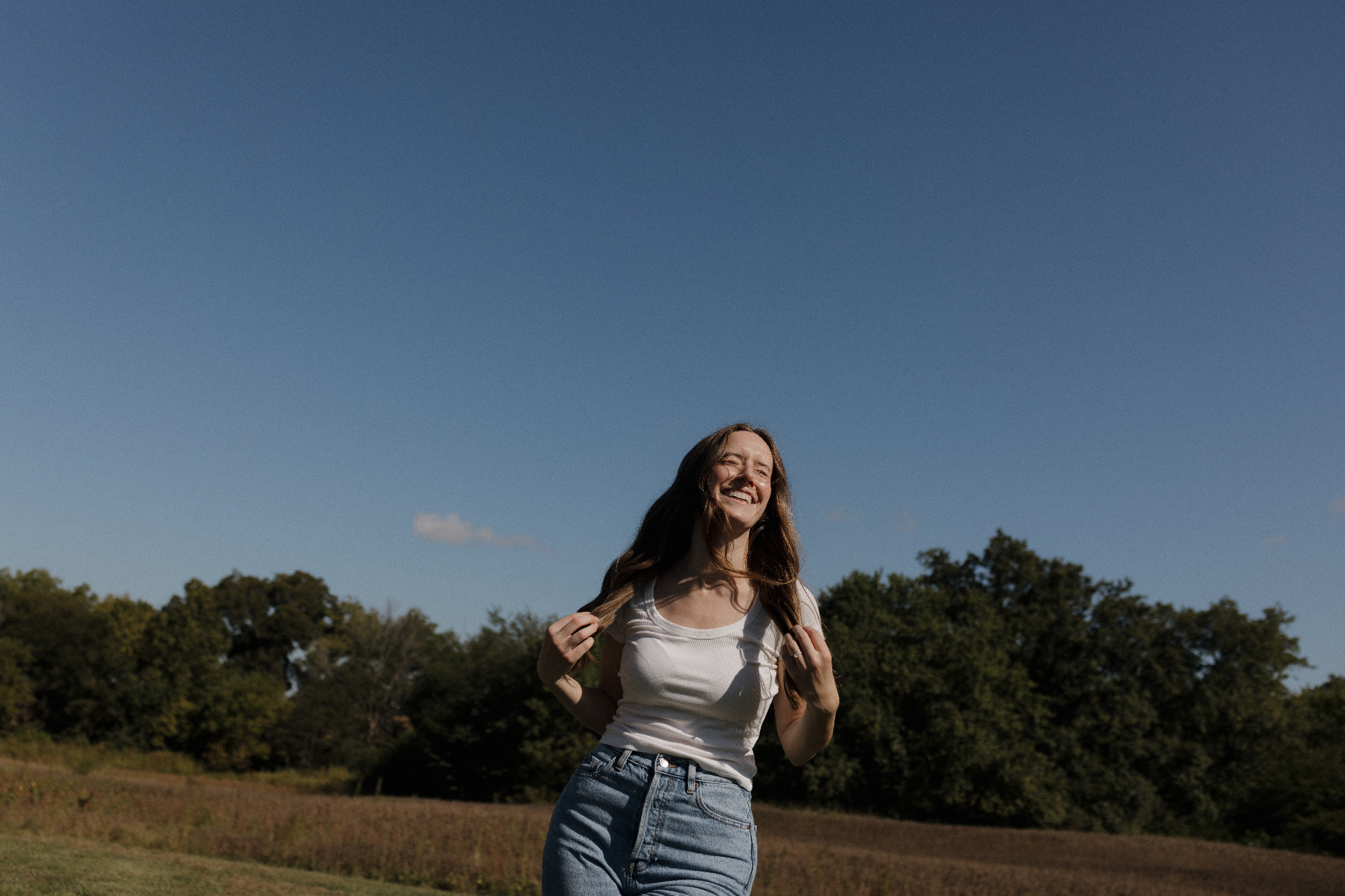 Ariel smiling in a sunlit field